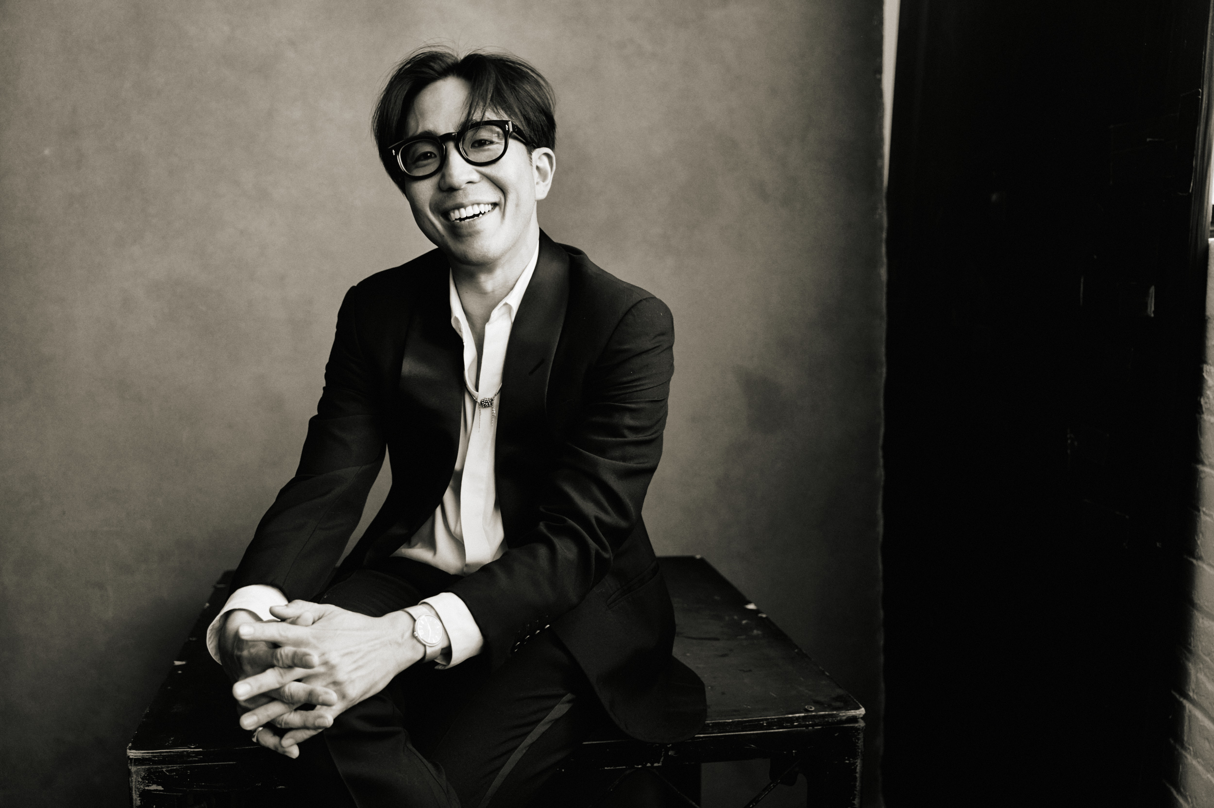 Kenta Koga seated cross-legged, smiling