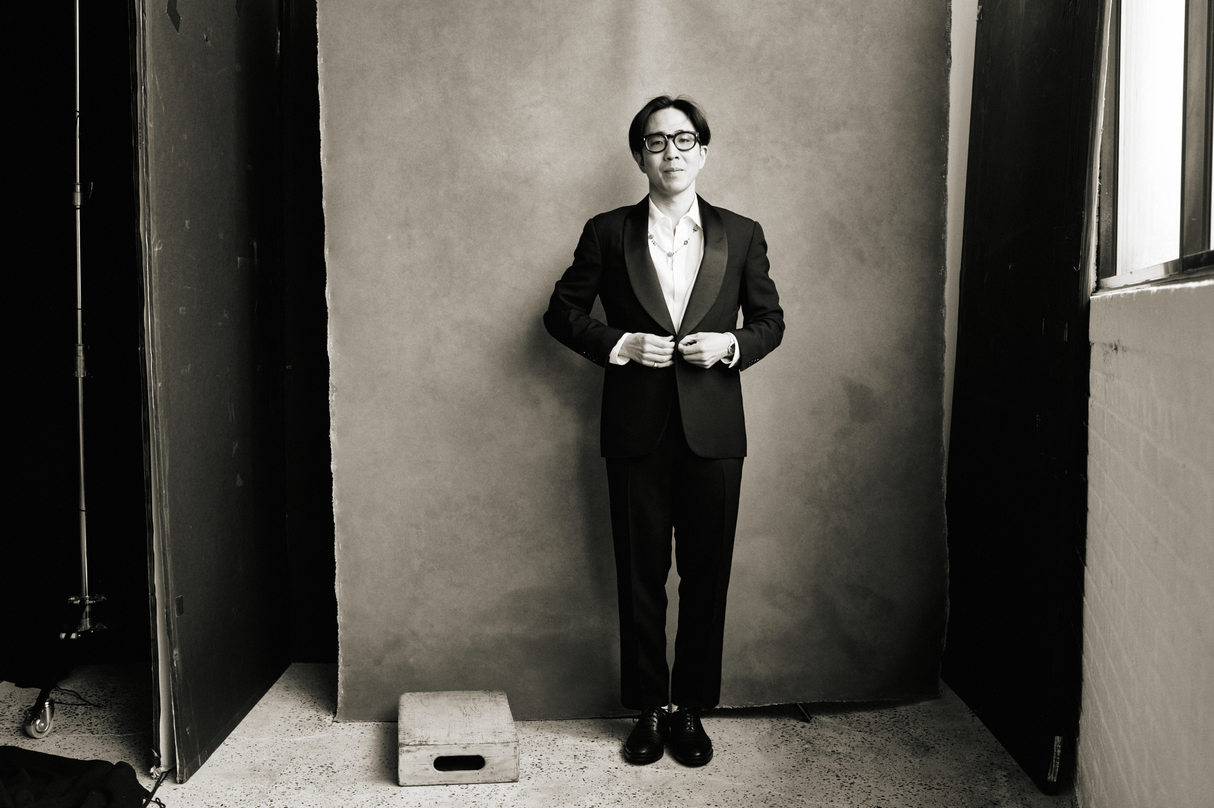Kenta Koga buttoning his tuxedo in Zenith Richards’s studio